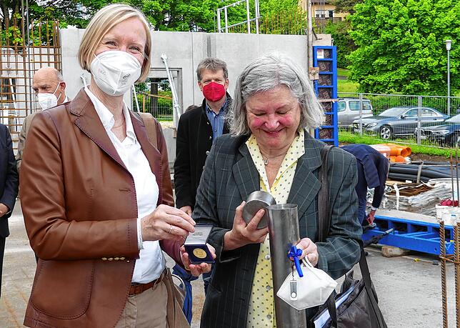 Landrätin Stefanie Bürkle legte eine Medaille in die Zeitkapsel von Sophie Schwörer. Im Hintergrund schaut der Landrat des ...