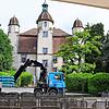Der Fahrer eines LKW lädt mit seinem Kran die Gewichte für die Kino-Leinwand im Schlosspark Bad Säckingen ab.