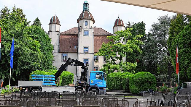 Der Fahrer eines LKW lädt mit seinem Kran die Gewichte für die Kino-Leinwand im Schlosspark Bad Säckingen ab.