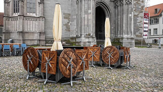 Zusammengeklappte Tische stehen auf dem Münsterplatz in Konstanz.