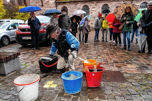 Gunter Demnig beim Verlegen der Stolpersteine auf dem Münsterplatz bei Regen.