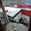 Von Schlamm und Geröll zerdrückt klemmt "Oli's 73er"-Imbisswagen auf dem Parkplatz beim Thomas Philipps-Markt an der Gebäudewand.