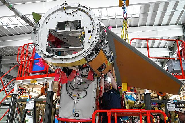 Hier wird einer der beiden Entenflügel an den Rumpf montiert. Durch diese Technik erhält der Eurofighter seine besondere Beweglichkeit.