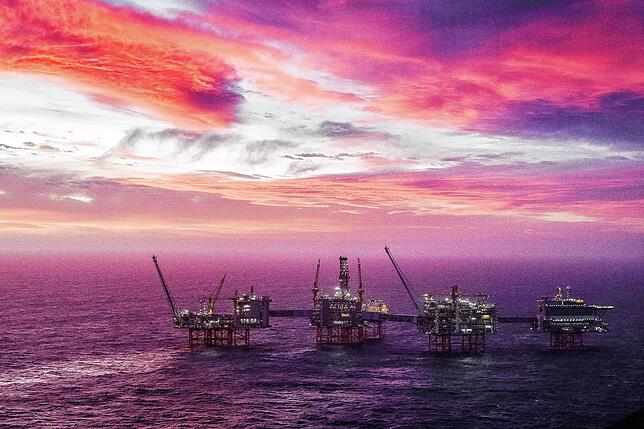 Der Himmel erleuchtet in lila und pink hinter dem Johan Sverdrup Ölfeld in der Nordsee. Es ist das drittgrößte Ölfeld auf dem ...