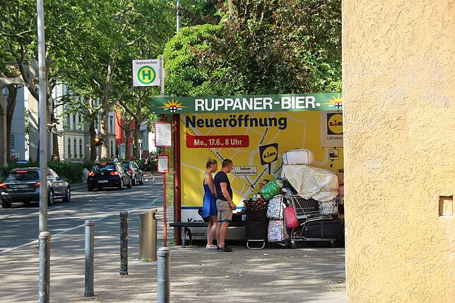 Passanten stehen neben der Frau und unterhalten sich mit ihr. Ihr Schicksal bewegt viele Menschen in Konstanz.