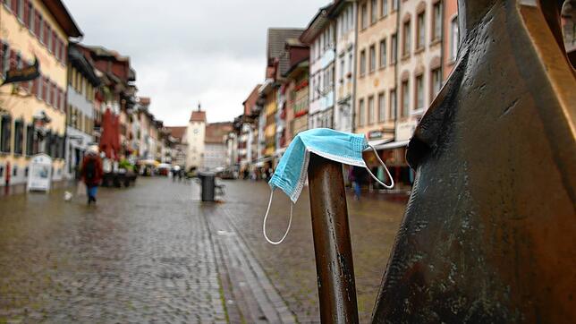 Eine Maske liegt in der Walsdhuter Kaiserstraße auf einer Skulptur. Ab sofort muss in den Fußgängerzonen im Kreis Waldshut nur noch eine ...