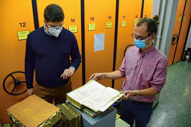Archivleiter Johannes Waldschütz und Mitarbeiter Christopher Wangenheim zeigen alte Ratsprotokolle im Stadtarchiv Stockach.