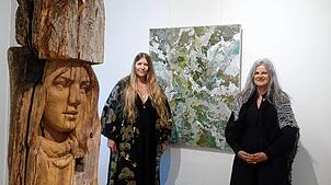 Paulina Vogt (links) und Bettina Bohn beteiligen sich an der Ausstellung „Heimat“ in der Villa Berberich. Links ist eine Holzskulptur ...