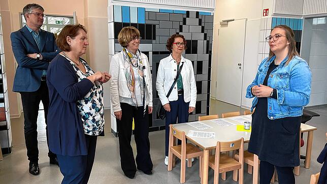 Kultusministerin Theresa Schopper (vorne links) lässt sich von der Leiterin der Kita Münchried Julia Schmid (rechts) das offene Konzept ...