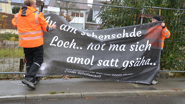 Die Bauhofmitarbeiter Karl-Heinz Hess (links) und Alexander Ley hängen die Banner auf Anordnung von Bürgermeister Edgar Lamm wieder ab. ...