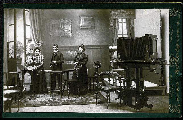 Dieses Bild zeigt das Fotoatelier von Gustav II. Hotz. Seine Schwester Katharina hält Sohn Gustav III. auf dem Arm (links), daneben der ...