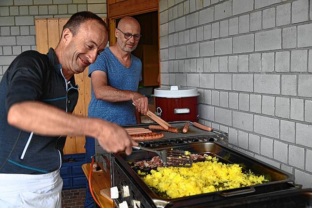 Georg Hilser verwöhnt die Gäste beim Skifreunde Vatertagshock mit Prägel. Im Hintergrund ist Stefan Moosmann am Wurstgrill zu sehen.