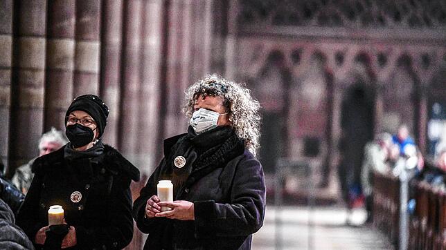 Menschen nehmen beim Silvester-Gottesdienst im Freiburger Münster an einem stillen Protest wegen der Entlassung des Domkapellmeisters ...