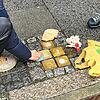 Die Stolpersteine in der Münsterstraße von der Familie Levi werden von Teilnehmern des Rundgangs geputzt.