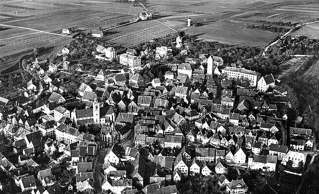 Diese Fliegeraufnahme wurde als Postkarte veröffentlicht und im Jahr 1920 verschickt. Der damalige Wasserturm (ganz oben) stand noch auf ...
