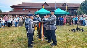 Eine Abordnung von sechs Rekruten spricht an der Truppenfahne stellvertretend für alle Rekruten die Gelöbnisformel.