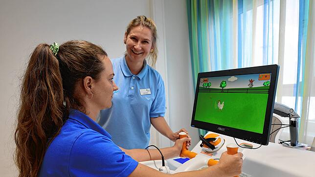 Sabrina Disch und ihre Kollegin Francoise-Justine Wysotzki (von rechts) demonstrieren die Nutzung des Tyromotion, einem Therapiegerät ...