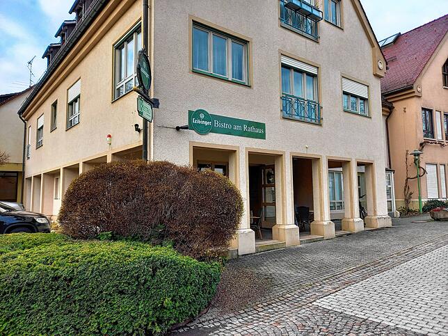 Mitten im Dorf und neben dem Rathaus: Das Bistro liegt im Teuringer Ortskern. Im Sommer ist auch draußen unter und vor den Arkaden bestuhlt.