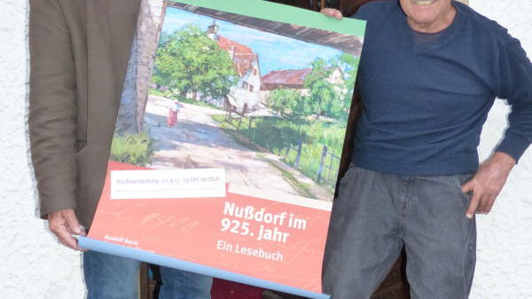 Dietram Hoffmann (links) und Rudolf Beck präsentieren das Plakat, das den Buchumschlag der Nußdorfer Chronik zeigt. Sie wird am Freitag, ...