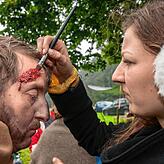 Stefan Eret wird von einer Maskenbildnerin eine Wunde an der Stirn geschminkt.