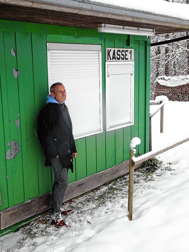 Martin Senn von der Betreiberfamilie blickt vor dem geschlossenen Kassenhäuschen skeptisch auf den verwaisten Lifthang.