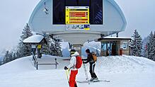 Zwei Skitourengeher stehen vor der Bergstation im Skigebiet am Spitzingsee. Die Wintersportorte in den deutschen Alpen starten mit ...