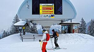 Zwei Skitourengeher stehen vor der Bergstation im Skigebiet am Spitzingsee. Die Wintersportorte in den deutschen Alpen starten mit ...