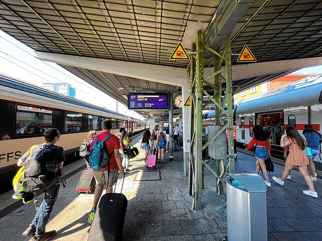 Links ein Zug der Schweizer Bundesbahn (SBB) nach Zürich, rechts ein Zug nach Stuttgart. Die Züge warten im Bahnhof von Singen.