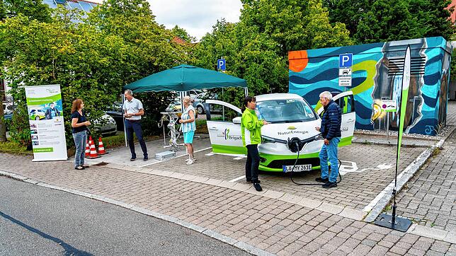 Bürgermeister Michael Schmitt und Cornelia Kammerlander erklären interessierten Bürgern das neue Carsharing in Brigachtal.
