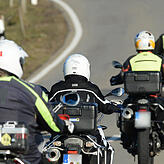 Eine Gruppe Biker auf kurvenreicher Strecke. Gut sichtbare gelb-schwarze Motorradjacken werden immer öfter getragen.