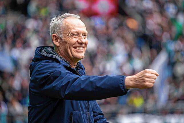 Freiburgs Trainer Christian Streich betritt das Stadion und lacht.