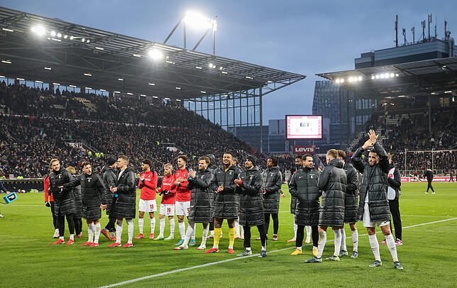 Freiburgs Spieler feiern mit den Fans nach dem Spiel.