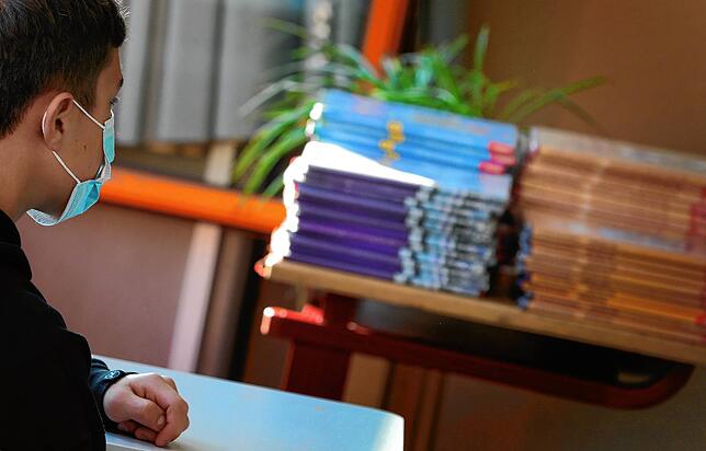 Ein Schüler sitzt am ersten Schultag zu Beginn des Unterrichts mit Mundschutz in einem Klassenzimmer in Bayern. In Baden-Württemberg ...