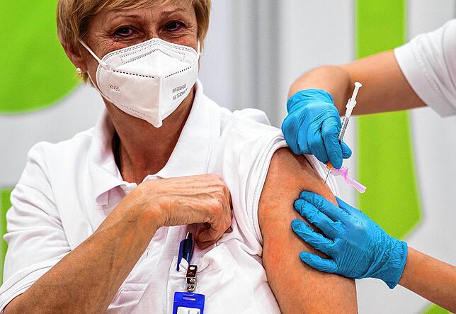 Eine Klinikangestellte in Wien wird zum Auftakt am 27. Dezember geimpft. Nach aktuellen Umfragen ist nur jeder zweite Angestellte eines ...