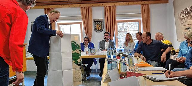 Bürgermeister Michael Kollmeier zeigt auf einer Karte den Flächennutzungsplan Sumpfohrens, dabei insbesondere des neuen Baugebietes.