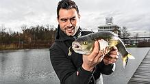 Enrico di Ventura, amtierender Weltmeister im Raubfischangeln, am Messesee mit einem Döbel in den Händen.