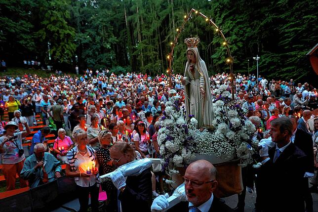 Eine Marienfigur wird während einer Lichterprozession am Wallfahrtsort Maria Vesperbild von Gläubigen getragen.