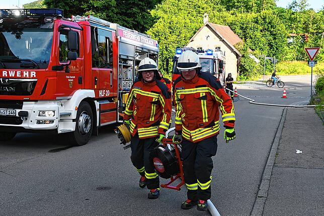 Die Feuerwehrleute holen ein Gerät zur Belüftung.
