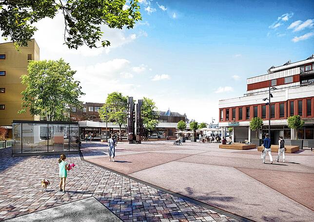 Variante 5: Rötlicher Ortbetonbelag in der Mitte und Natursteinpflaster entlang der Ränder der Gebäude des Marktplatzes.