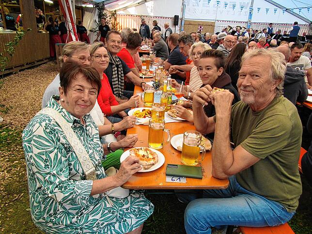 Die guten Dinnetle direkt vom Holzbackofen beim Langenharter Fest lassen sich die Gäste schmecken.