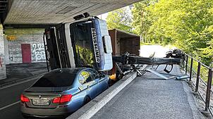 Ein Lastwagen ist mit seinem Kran in Neuenhof (Kanton Aargau) an der Brücke hängen geblieben und auf das Auto gekippt.