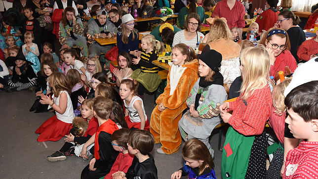 Dichtgedrängt sitzen die Kinder an den Tischen und vor der Darstellungsfläche.