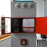 Ein Lehrstück: Diverse Rauchwarnmelder, Feuerwehr-Anzeigetableau und Lagepläne eines öffentlichen Gebäudes. Hier prüft die Feuerwehr bei ...