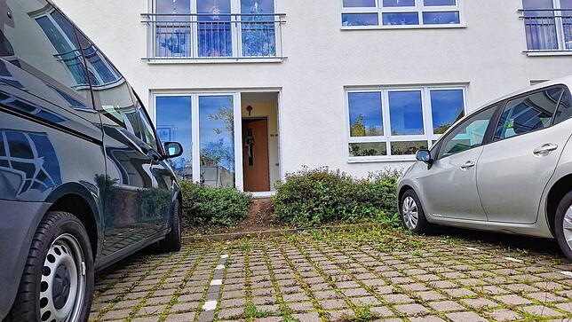 Ein schwarzer Van der Kriminaltechnik parkt vor dem Gebäude.