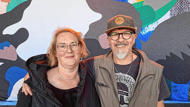 Melanie und Rainer Faller aus Markdorf auf der Bühne vor dem bunten Hintergrund von LaBrassBanda.