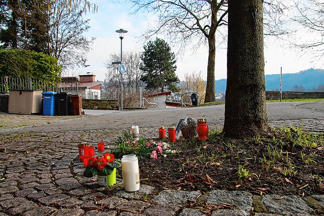 An einem Baum bei der Straße am Stadtwall in Stockach haben Menschen Kerzen aufgestellt und Blumen abgelegt, um der Toten 24-Jährigen zu ...
