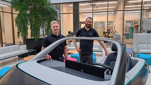 Felix Hake, Produktentwickler, und Dominik Schuster, Software- und Hardware-Entwickler stehen an ihrem Democar 2.0.