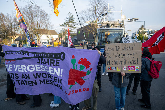 Teilnehmer einer Demonstration gegen die AfD stehen vor der Bundesgeschäftsstelle der AfD, in der der Wahlabend der Partei gefeiert wird.
