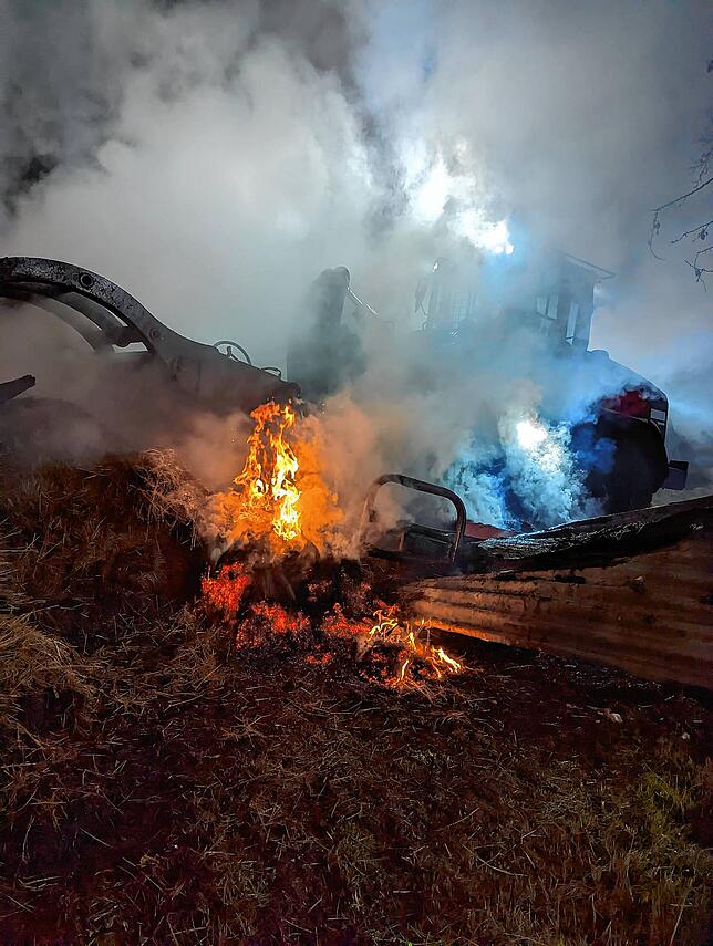 Zwischen Massen an Stroh und Heu bekommt das Feuer immer weiter Nahrung – und brennt auch am Montag noch.