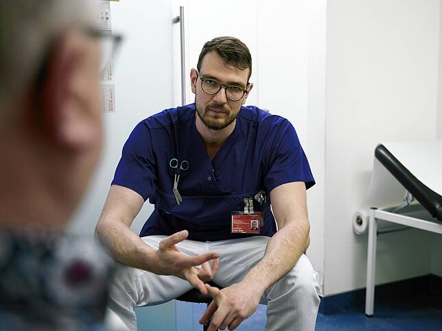 Peter Bahr erklärt einem Patienten, wie er seine Wunde am besten versorgt.